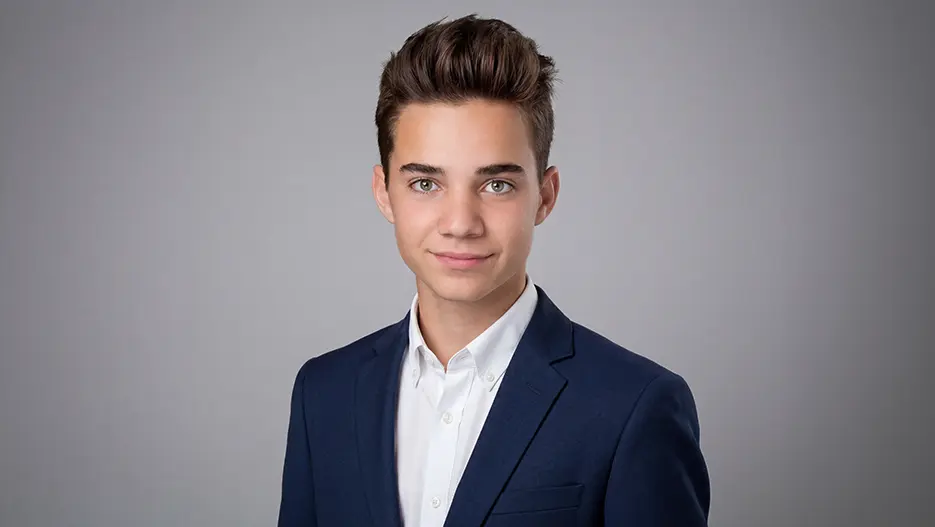 Bewerbungsbild eines jungen Mannes im Sakko vor hellgrauem Hintergrund für Ausbildung oder Praktikum