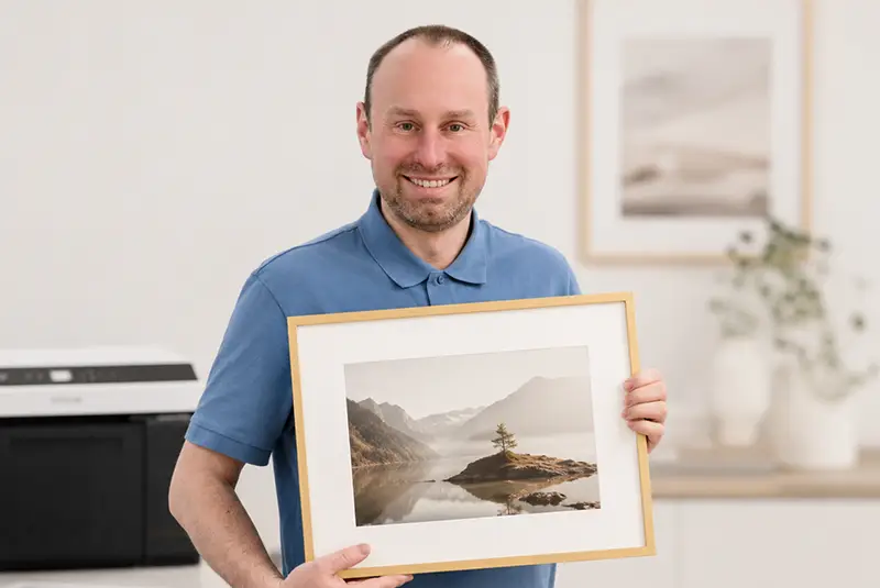 Manfred Wagner mit einem gerahmten Bild im Fotostudio in München-Pasing