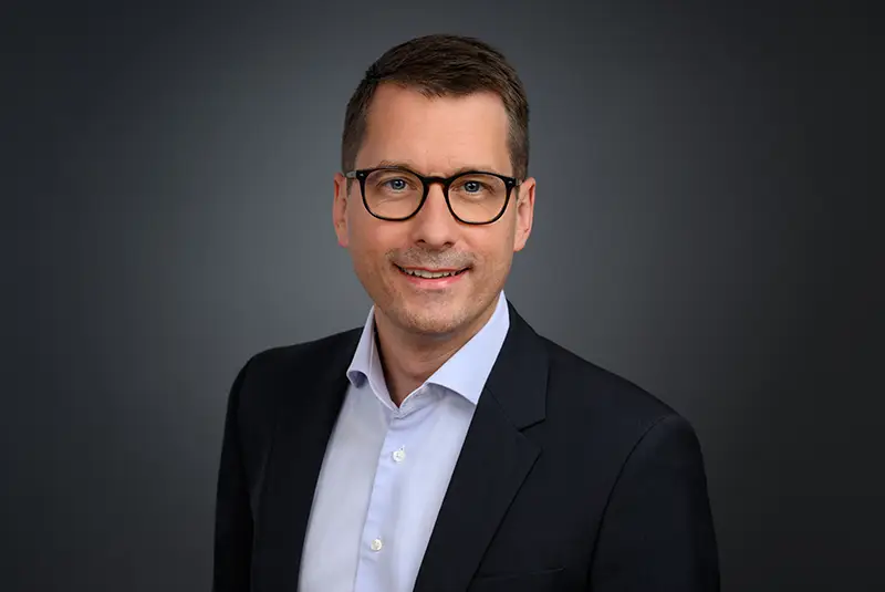 Bewerbungsfoto eines Mannes mit Brille, ohne störende Spiegelungen im Glas