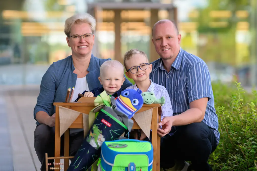 Familienbild zur Einschulung vor der Schule