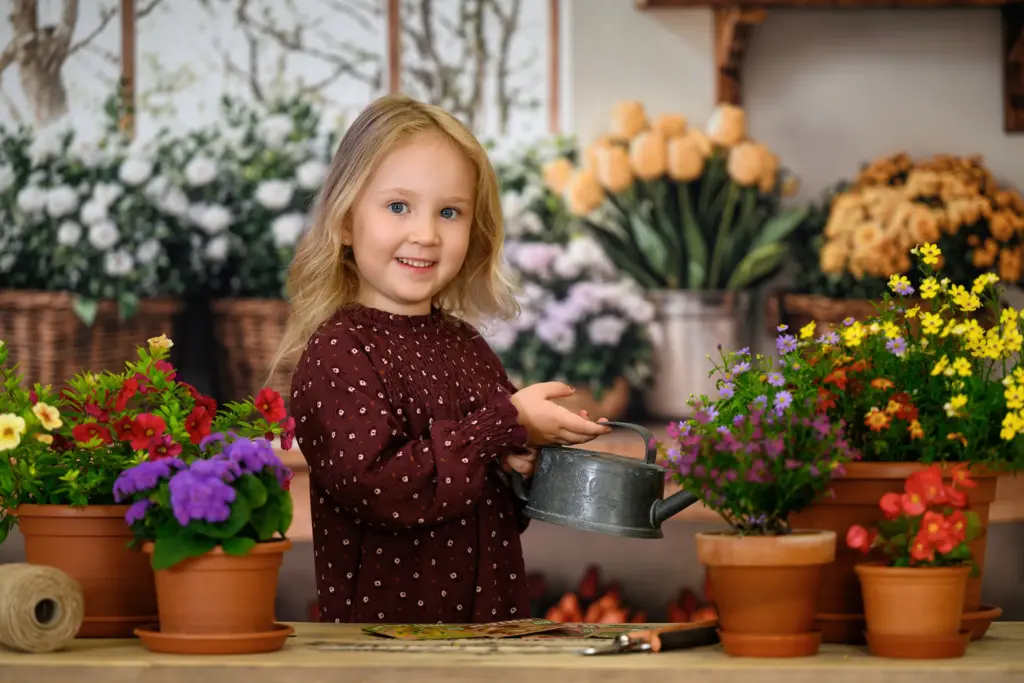 Mädchen zwischen Blumentöpfen bei der Kindergartenfotografie