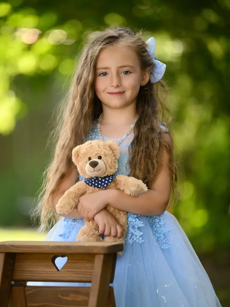 Mädchen mit Teddybär beim Fototag im Kindergarten