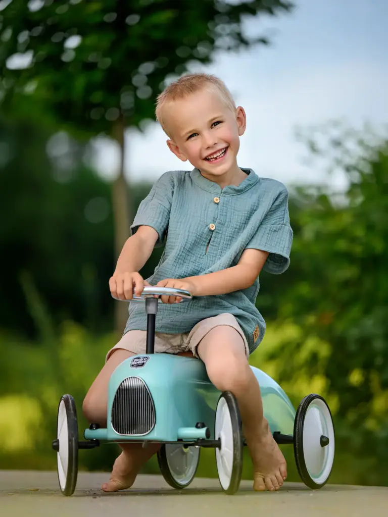 Junge auf dem Rutschauto beim Kindergarten-Fototag
