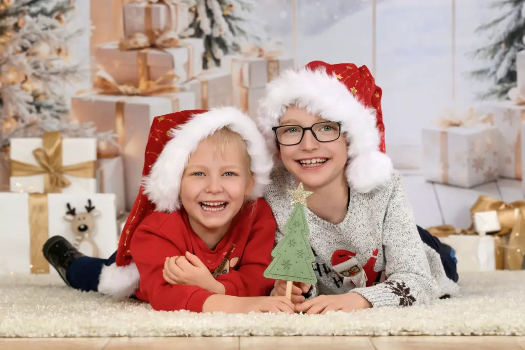 Zwei Kinder mit Weihnachtsmützen bei der Weihnachtsaktion im Kindergarten